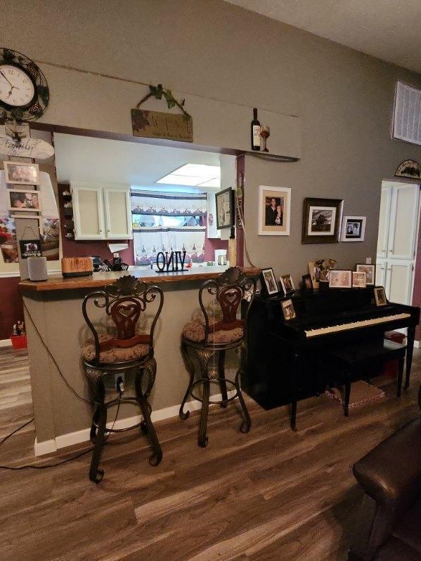 bar featuring white cabinetry and wood-type flooring