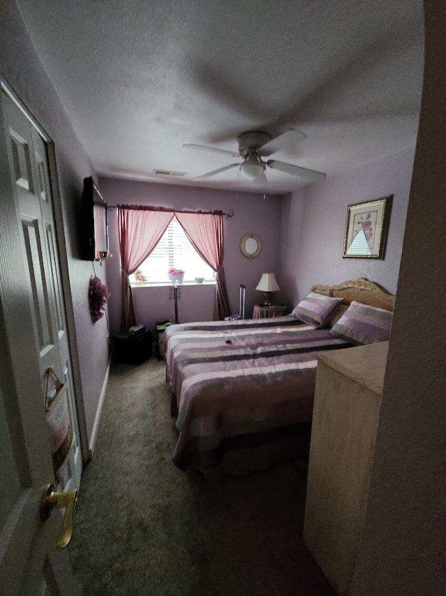 carpeted bedroom with a textured ceiling and ceiling fan