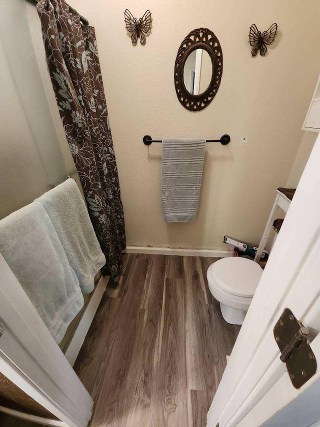 bathroom featuring toilet and wood-type flooring