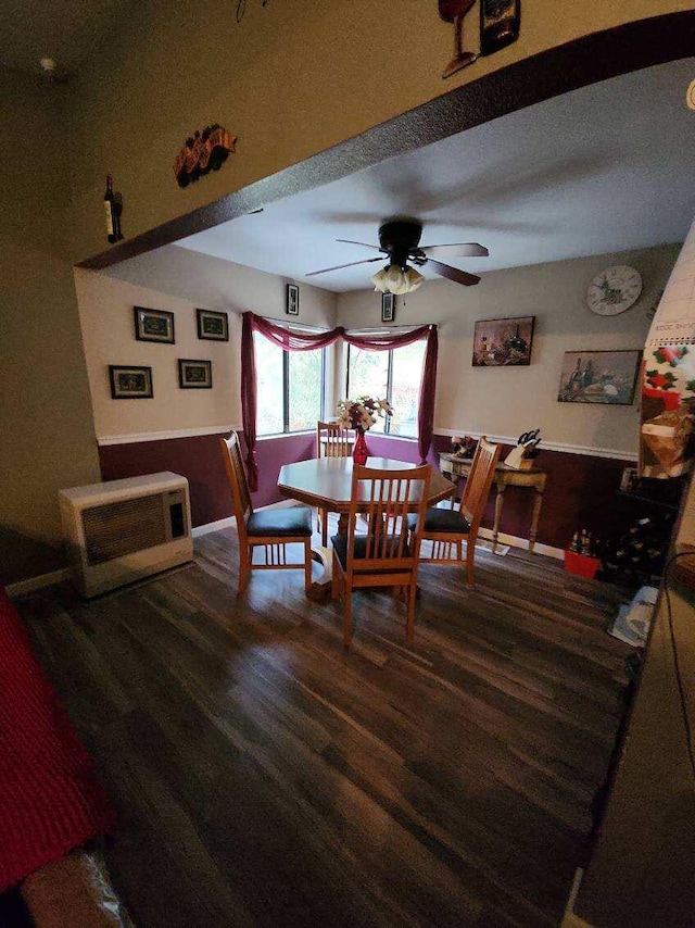 dining space with dark wood-type flooring, ceiling fan, and heating unit