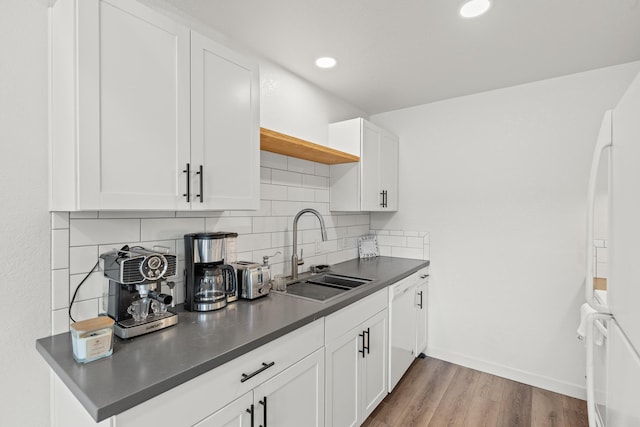 kitchen featuring sink, white cabinets, backsplash, white fridge, and light wood-type flooring