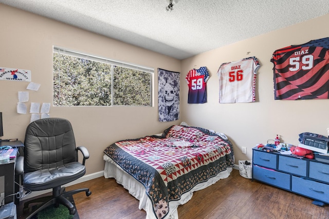 bedroom with a textured ceiling and dark hardwood / wood-style floors