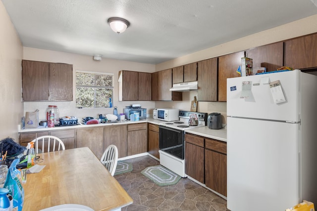 kitchen with a textured ceiling and white appliances