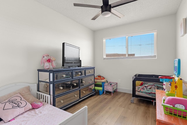 bedroom with hardwood / wood-style flooring, ceiling fan, and a textured ceiling