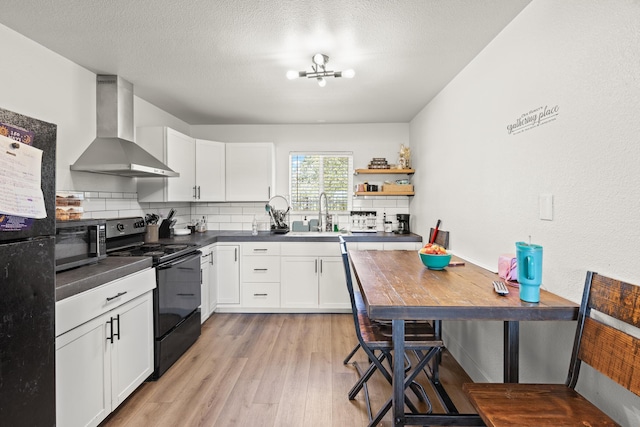 kitchen featuring white cabinets, sink, wall chimney exhaust hood, and black appliances