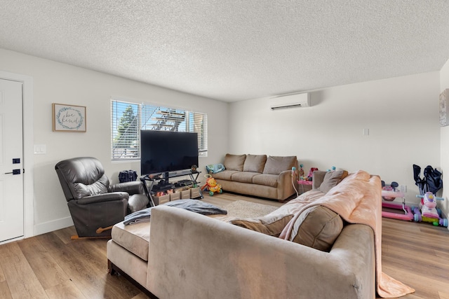 living room featuring a textured ceiling, hardwood / wood-style floors, and a wall mounted air conditioner