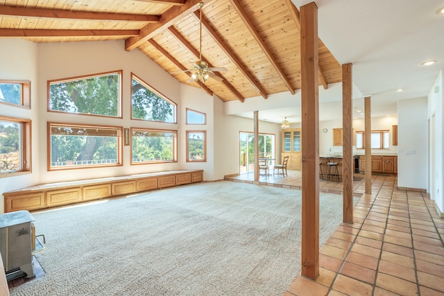 unfurnished living room with beamed ceiling, tile patterned floors, ceiling fan, and high vaulted ceiling