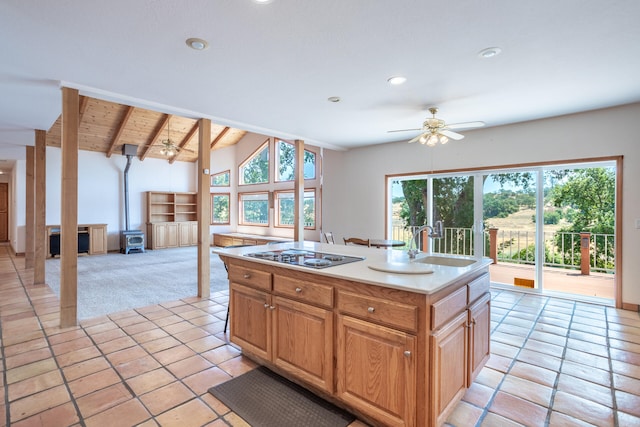 kitchen featuring ceiling fan, vaulted ceiling with beams, an island with sink, light tile patterned floors, and wood ceiling