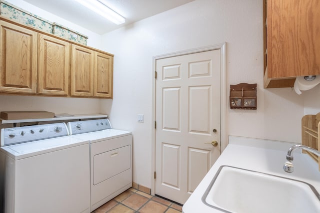 laundry area with sink, cabinets, washer and clothes dryer, and light tile patterned floors