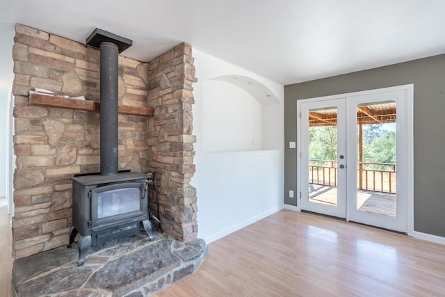 entryway featuring a wood stove, baseboards, french doors, and wood finished floors