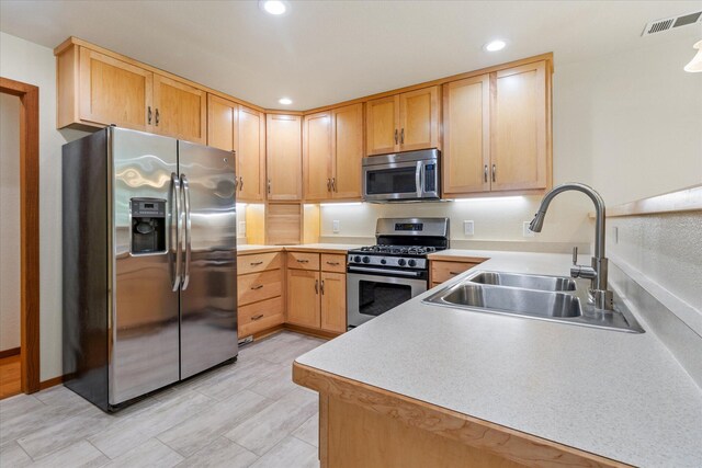 kitchen with light brown cabinetry, sink, and appliances with stainless steel finishes