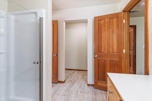 bathroom featuring vanity, wood-type flooring, and an enclosed shower