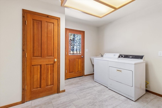 clothes washing area with washer and clothes dryer, sink, and light tile patterned floors