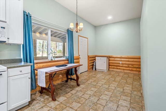 dining space featuring light tile patterned flooring, an inviting chandelier, and vaulted ceiling