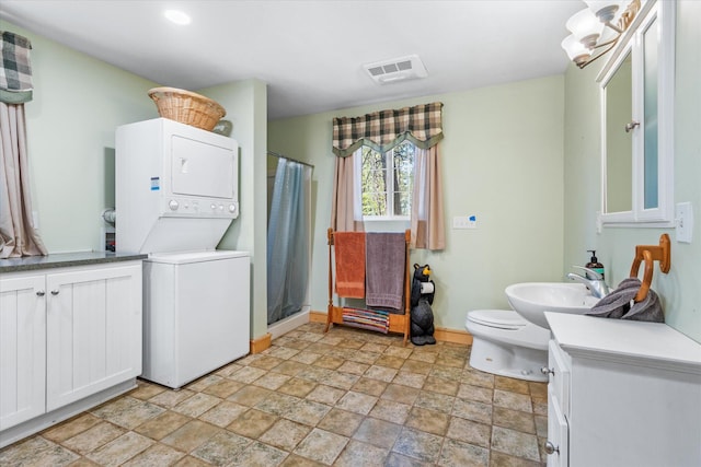 interior space featuring sink, stacked washer and dryer, and light tile patterned floors