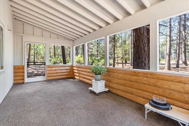 unfurnished sunroom with a healthy amount of sunlight and lofted ceiling with beams