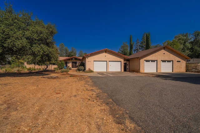 view of front facade featuring a tile roof, fence, and stucco siding