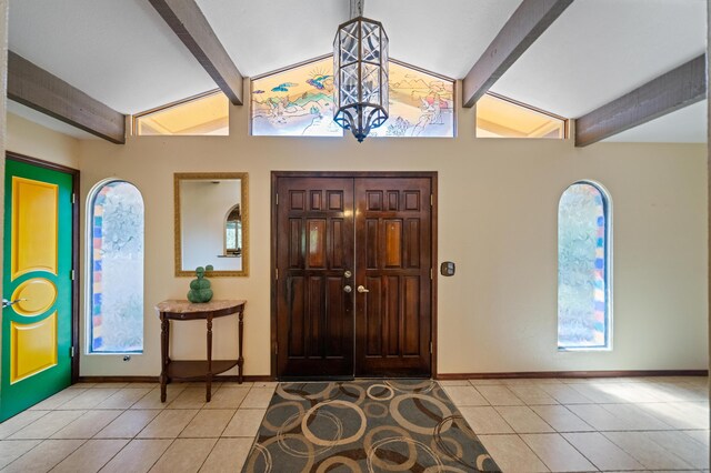 foyer with vaulted ceiling with beams and light tile patterned floors