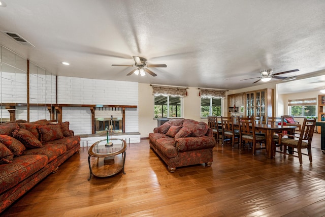 living room with wood-type flooring, a textured ceiling, and ceiling fan