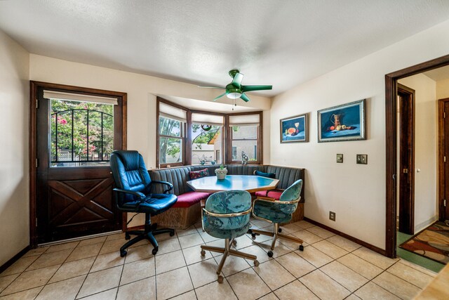 tiled dining space with ceiling fan