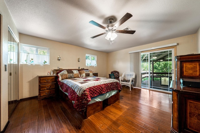 bedroom featuring access to exterior, dark wood-type flooring, a textured ceiling, and ceiling fan