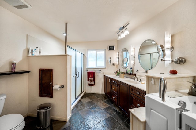 full bath with a stall shower, visible vents, toilet, stone finish flooring, and vanity