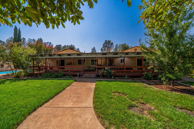 view of front of house featuring a front lawn and a swimming pool side deck