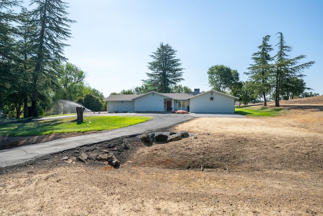 ranch-style home with a front lawn and aphalt driveway