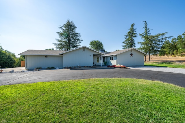 ranch-style house featuring aphalt driveway and a front lawn