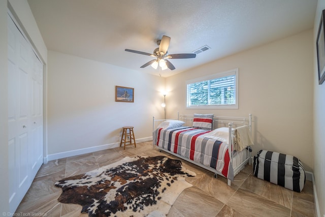 bedroom with baseboards, a closet, visible vents, and a ceiling fan