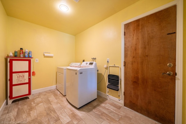 washroom with baseboards, laundry area, and washer and dryer