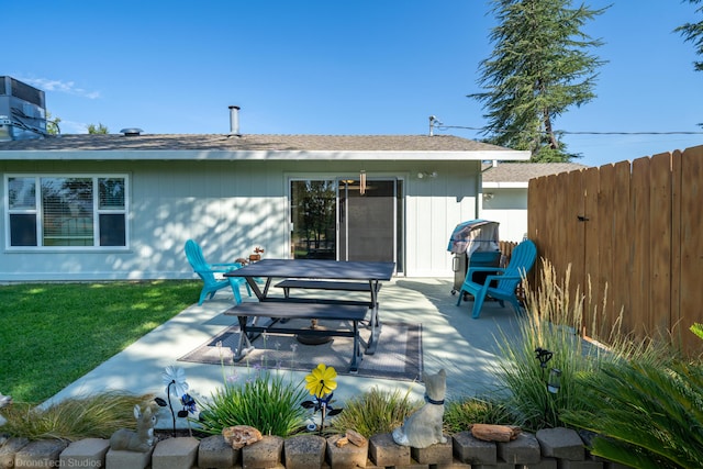 rear view of house featuring a yard, a patio area, and fence