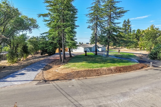 view of front of home featuring aphalt driveway and a front lawn