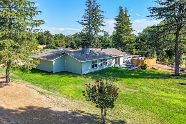 rear view of property featuring a lawn