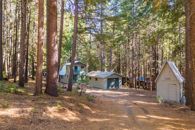 view of front of home with a garage and a shed