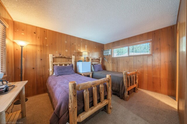 bedroom featuring wooden walls, a textured ceiling, and carpet floors