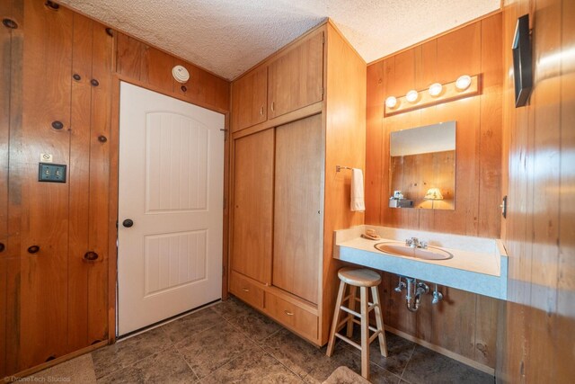 bathroom featuring a textured ceiling, sink, and tile patterned flooring