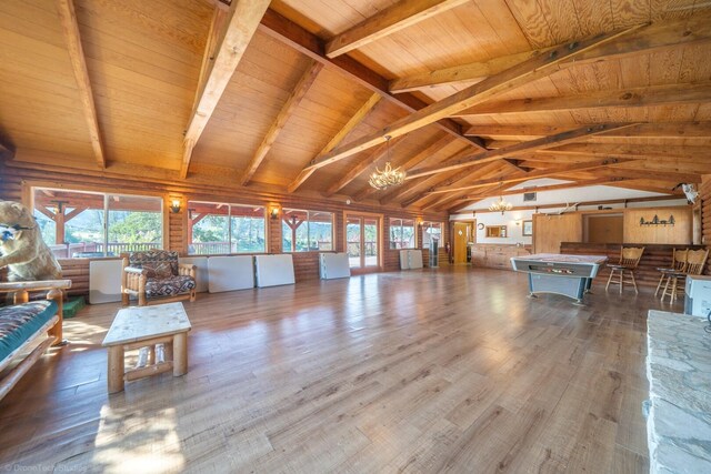 unfurnished living room featuring lofted ceiling with beams, an inviting chandelier, wood ceiling, and hardwood / wood-style flooring