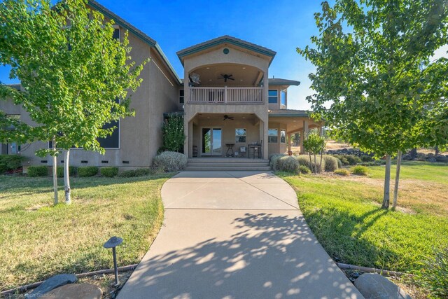 view of front of house featuring ceiling fan and a front lawn