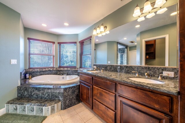 bathroom with double sink vanity, tile patterned floors, and tiled tub