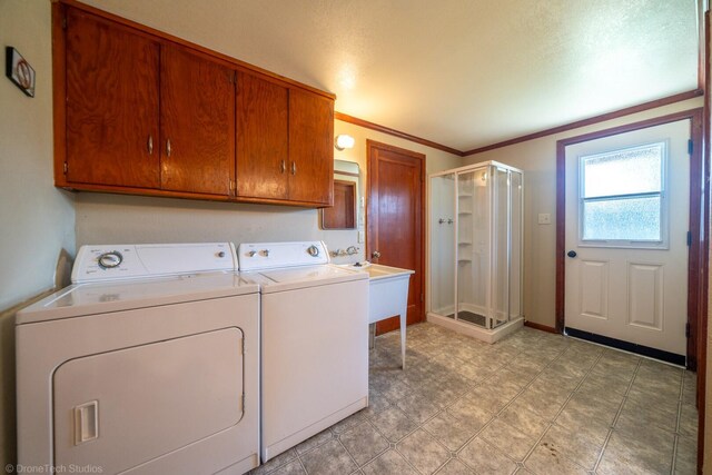 washroom with light tile patterned floors, cabinets, sink, ornamental molding, and washing machine and clothes dryer