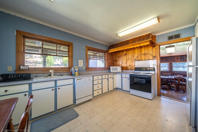 kitchen with white appliances, white cabinets, light tile patterned flooring, sink, and ornamental molding