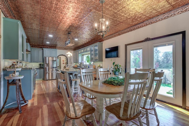 dining area featuring hardwood / wood-style flooring, a chandelier, and french doors