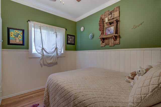 bedroom with ornamental molding, ceiling fan, and light hardwood / wood-style flooring