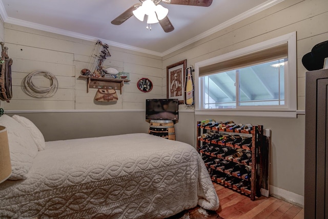 bedroom featuring crown molding, hardwood / wood-style flooring, wooden walls, and ceiling fan