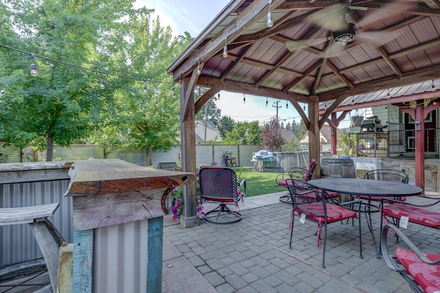 view of patio featuring ceiling fan, an outdoor bar, and a gazebo