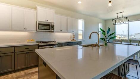 kitchen with sink, appliances with stainless steel finishes, white cabinetry, hanging light fixtures, and a spacious island