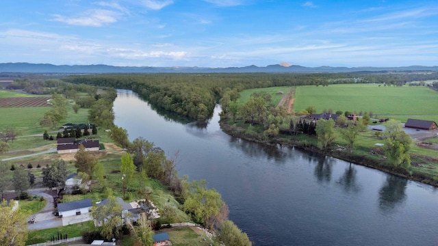 drone / aerial view with a water and mountain view and a rural view