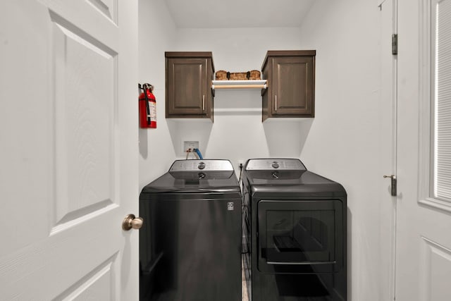 washroom with washer and clothes dryer and cabinets