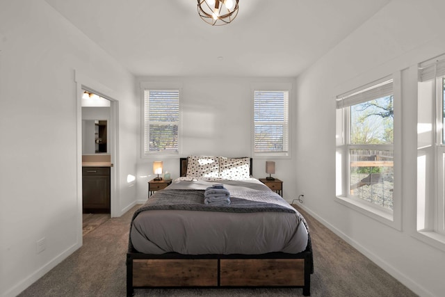 carpeted bedroom featuring connected bathroom and multiple windows